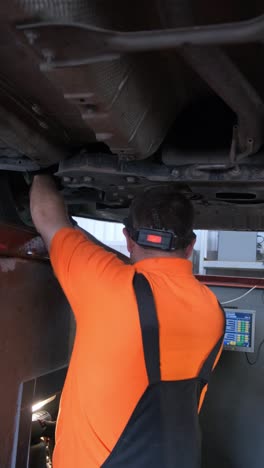mechanic working on the undercarriage of a car