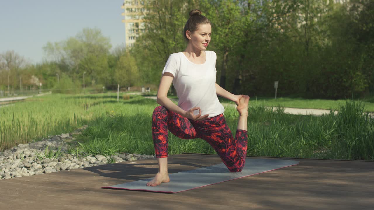 morena delgada haciendo giro de yoga en el parque
