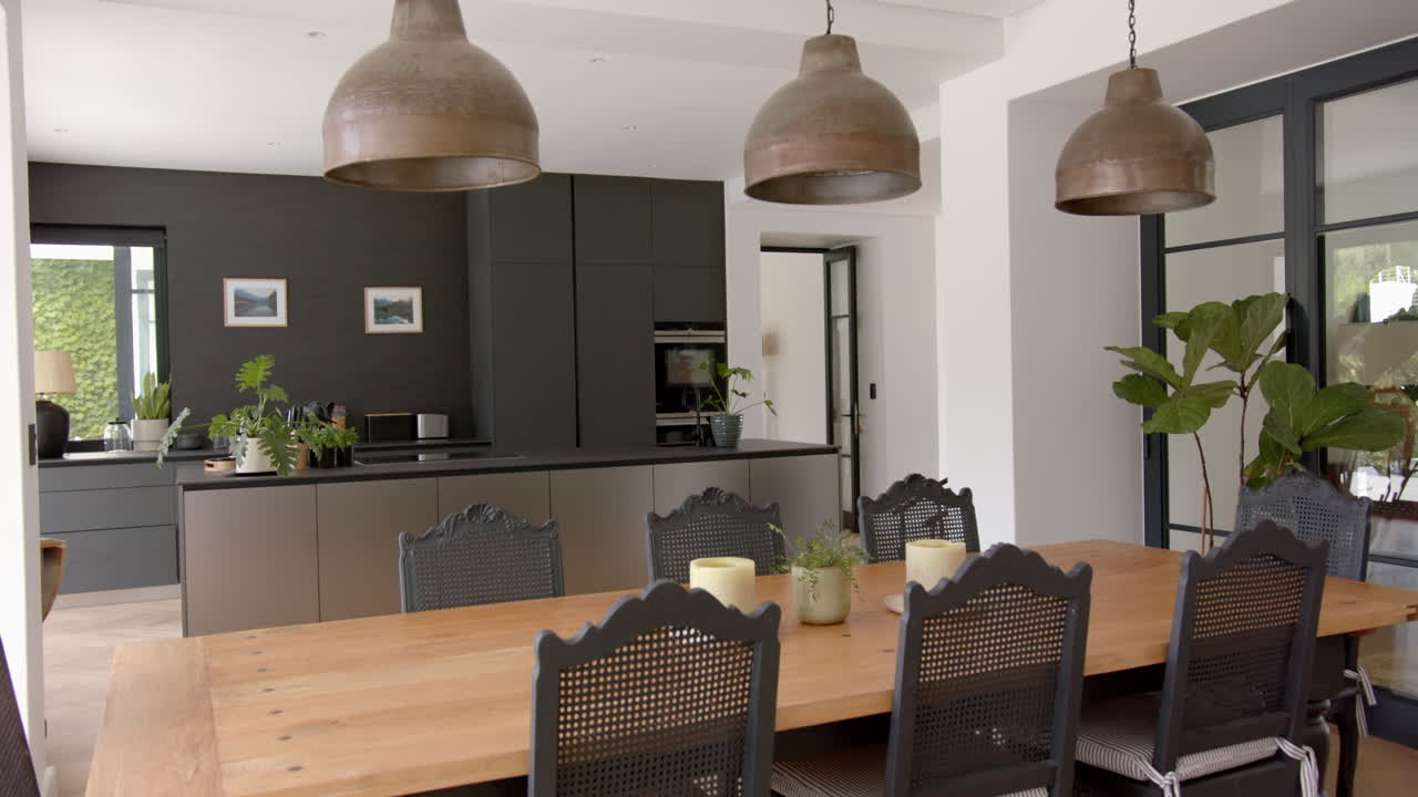 una cocina moderna con una mesa de comedor de madera y sillas negras