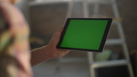 Man-hand-holding-tablet-at-house.-Unknown-woman-working-during-renovation