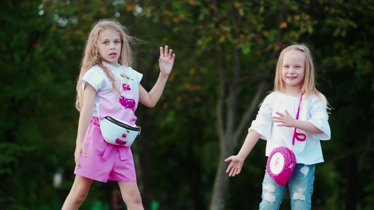 Kids In Park Outdoors. Two little happy girls dancing in park