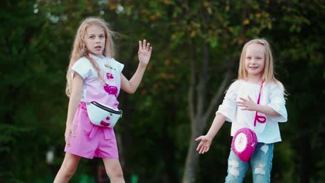 kids in park outdoors. two little happy girls dancing in park