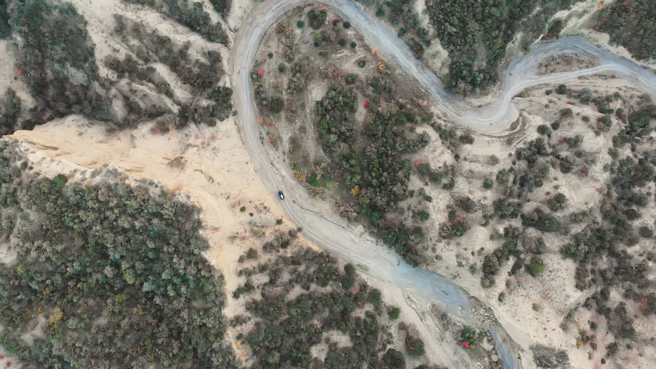 vista a vista de pájaros de un vehículo 4x4 montado en un camino de forma s en el valle del río con una vista panorámica de la naturaleza de otoño. viaje de aventura fuera de carretera extremo