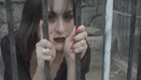 woman looking at camera as an animal stuck in cage