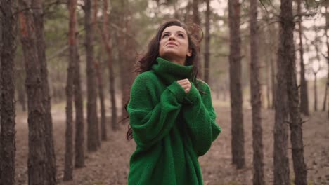 bella donna allegra da sola nella foresta che gode della libertà camminando verso la macchina fotografica