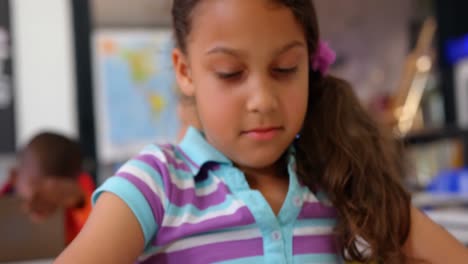 Front-view-of-Asian-schoolgirl-studying-on-digital-tablet-in-the-classroom-4k-`