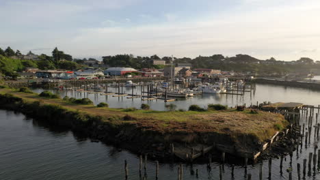 Wooden-Pilings-Near-Meadow-Harbor-With-Boats-Moored-During-Sunrise-In-Bandon,-Oregon