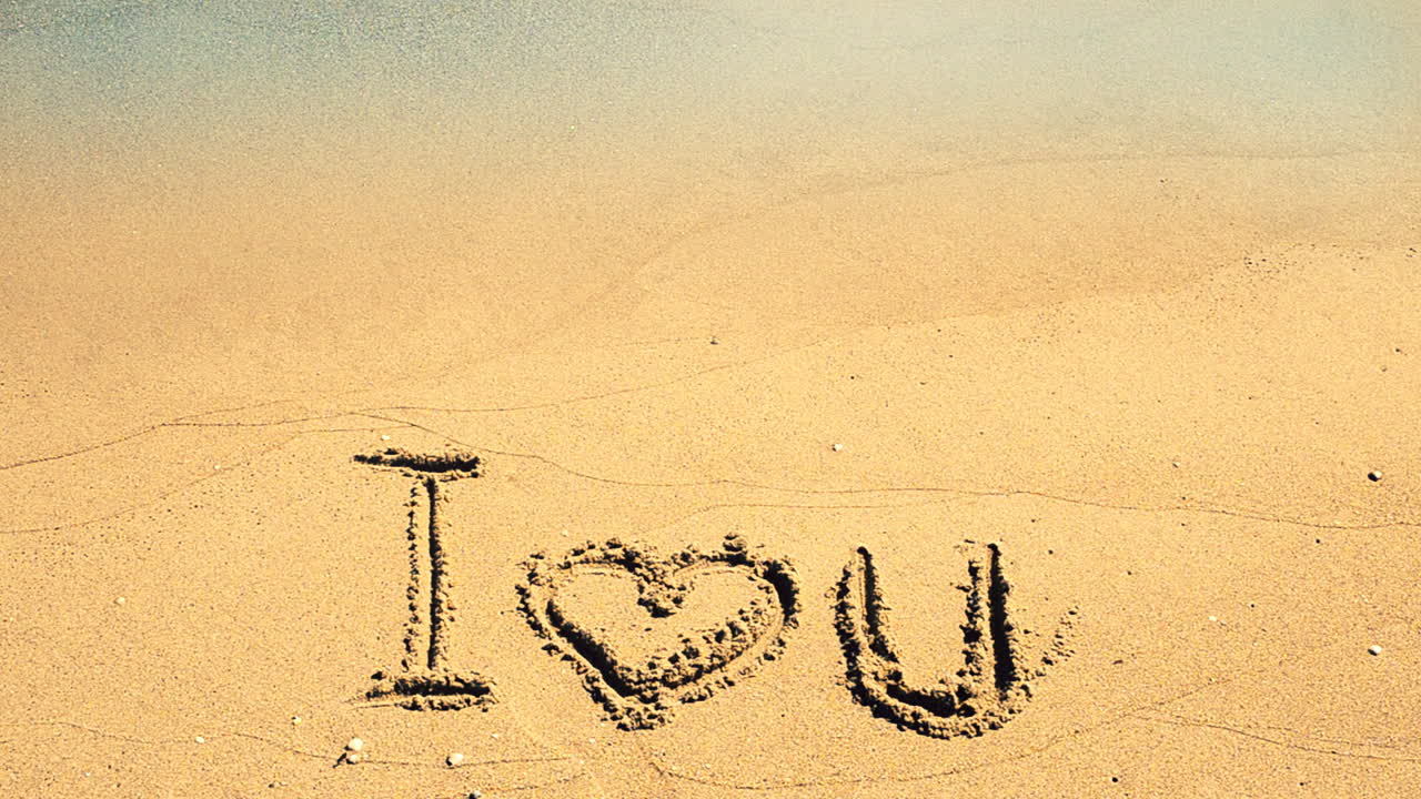 Inscription I love you on sand. Shooting on the beach