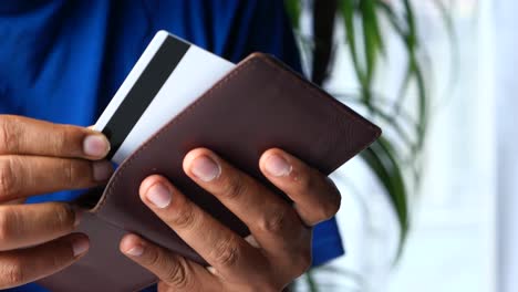 person holding a wallet and credit card