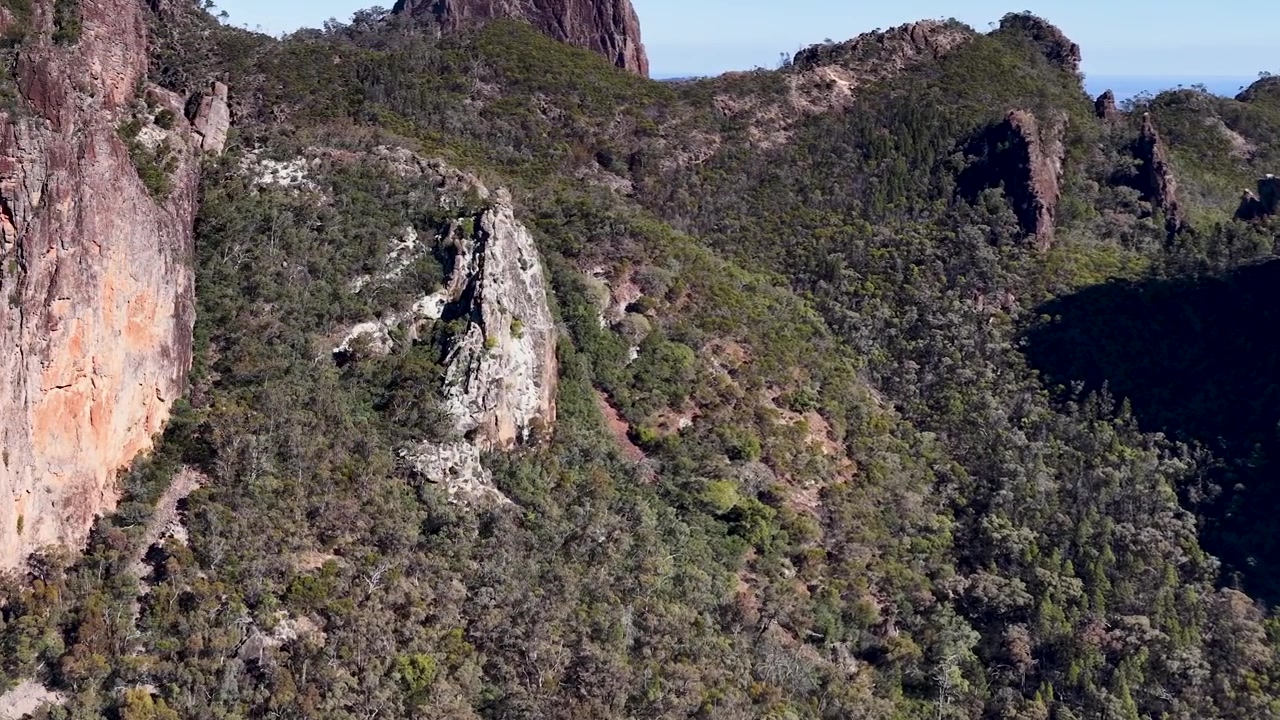 Vista Aérea de Picos de Montanhas Acidentados e Vale Florestado