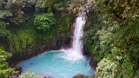 the iconic rio celeste waterfall with its turquoise pool underneath in northern costa rica on a cloudy day