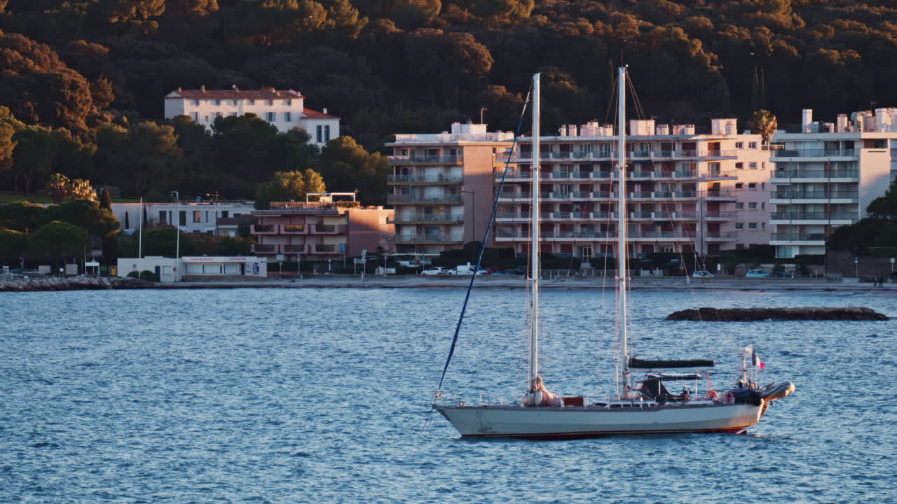 Juan-les-Pins, France - January 25, 2025: Small boat floating on the sea at sunset