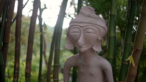 buddhist statue in a zen garden in a bamboo forest - concept: peaceful, spiritual, relaxation, gentle breeze, tranquil, restive, meditation