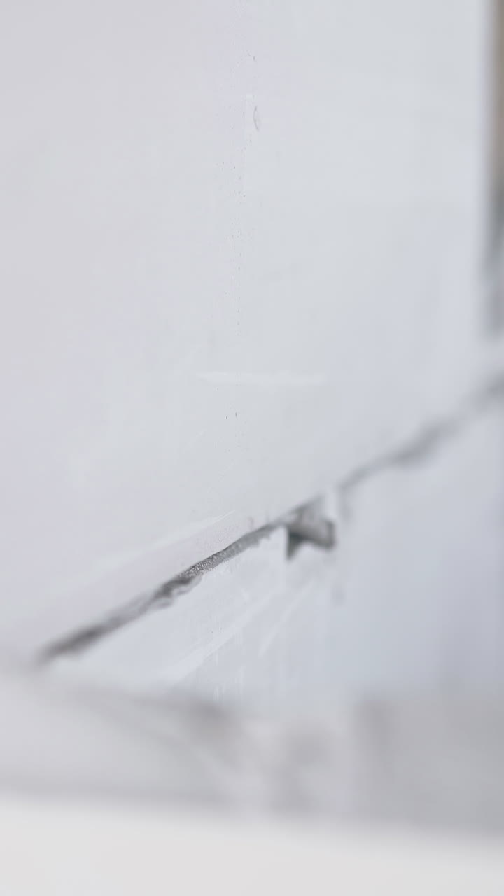 professional worker holds large grey gypsum pasteboard and puts on wall top with grey substance close view
