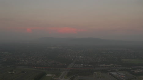 aerial view of city with smog at sunset