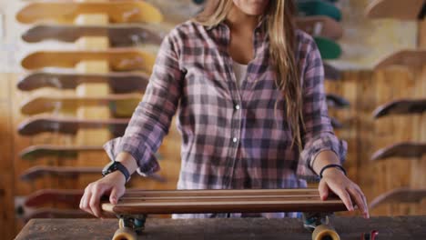 Video-of-happy-caucasian-female-skateboarder-in-skate-shop