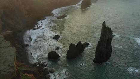 Aufschlussreiche-Drohnenaufnahme-Des-Kleinen-Schwarzen-Strandes-Neben-Den-Klippen-An-Der-Küste-Von-Madeira