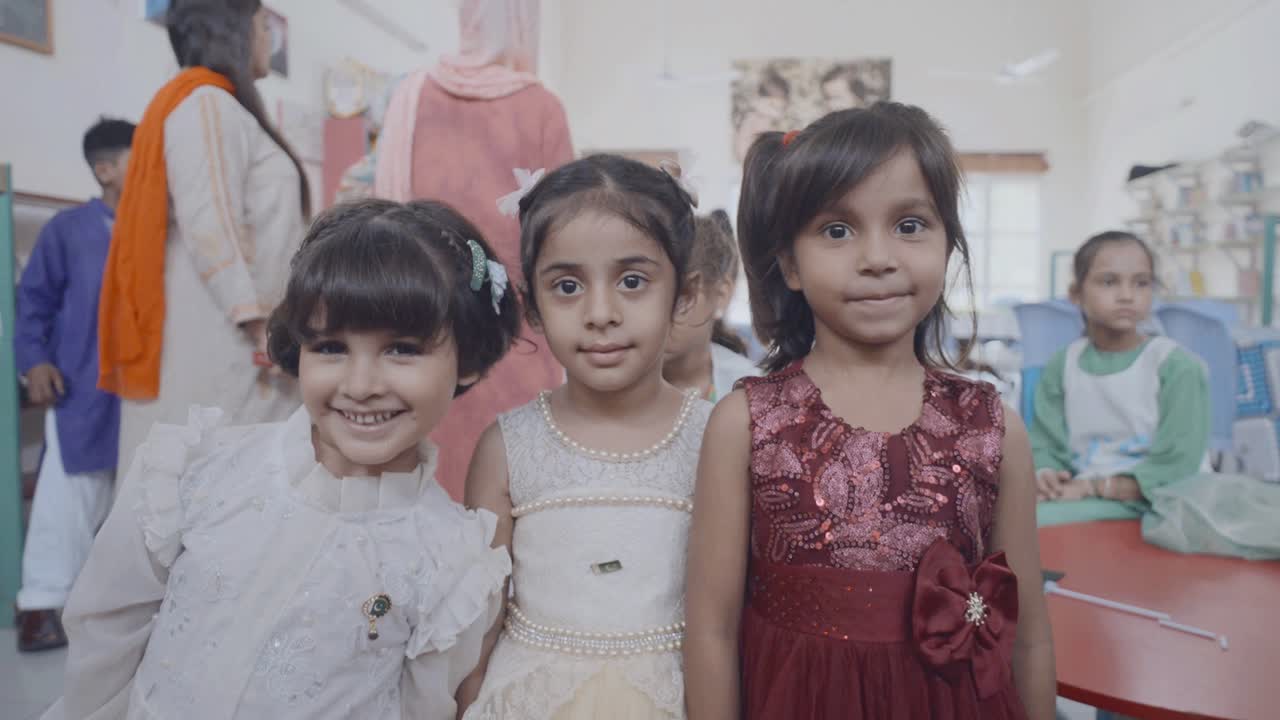 A joyful group of young children celebrating Independence Day in a school hall in Pakistan, showcasing patriotism and happiness.