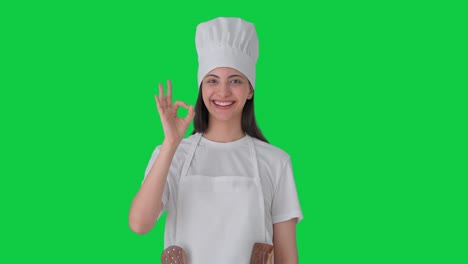 feliz india mujer chef profesional mostrando bien signo pantalla verde