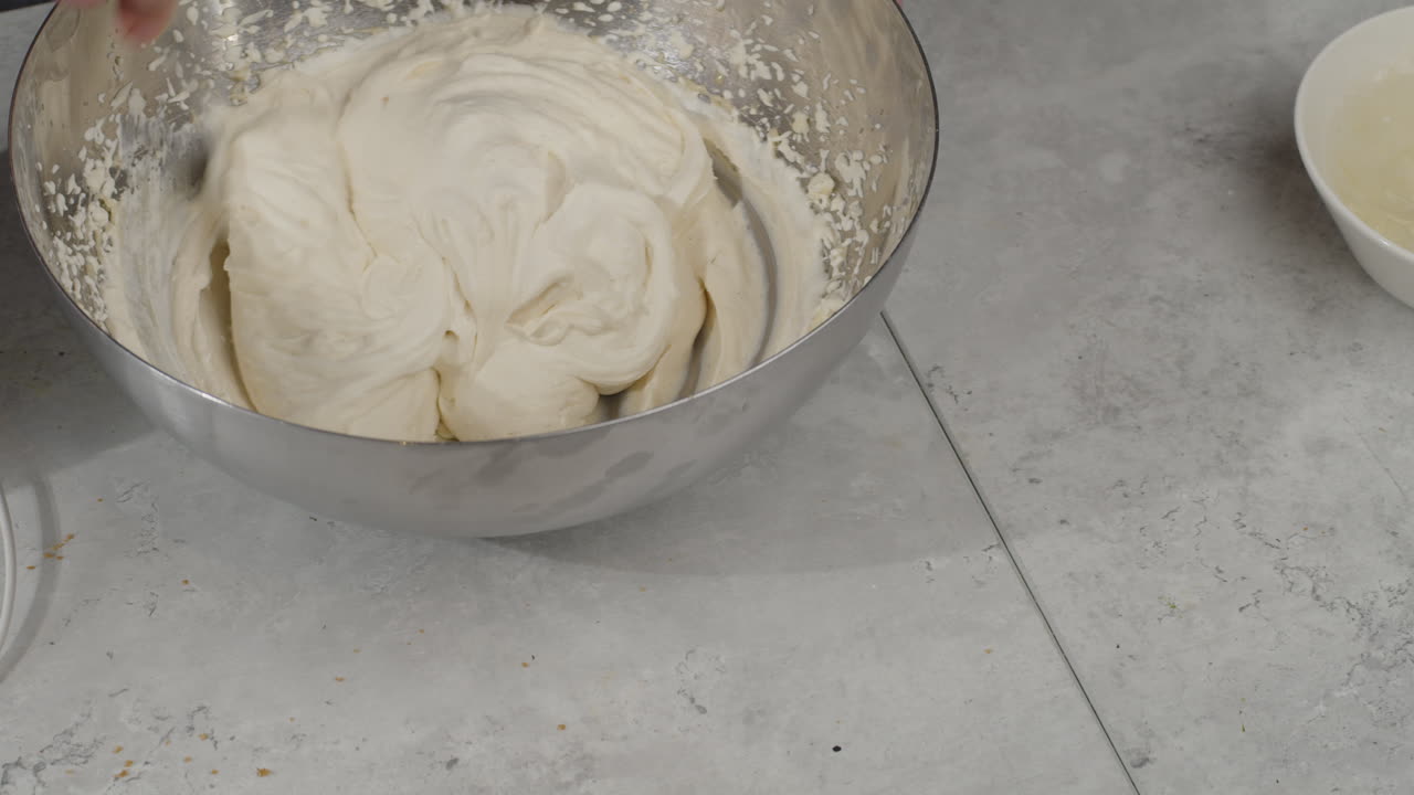 Overhead view of chef mixing whipped cream with spoon