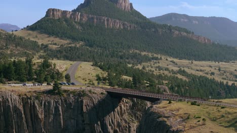 aerial approach to sunlight creek bridge in wyoming, capturing the bridge's height and the dramatic drop of the canyon below