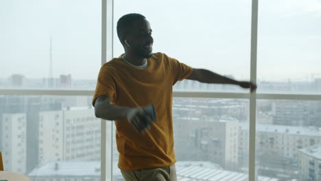 happy man dancing in modern office with city view
