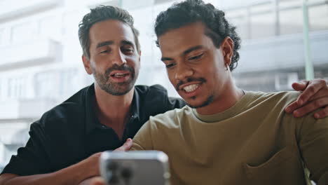 lgbt partners discussing internet purchases on cell phone sitting cafe close up.
