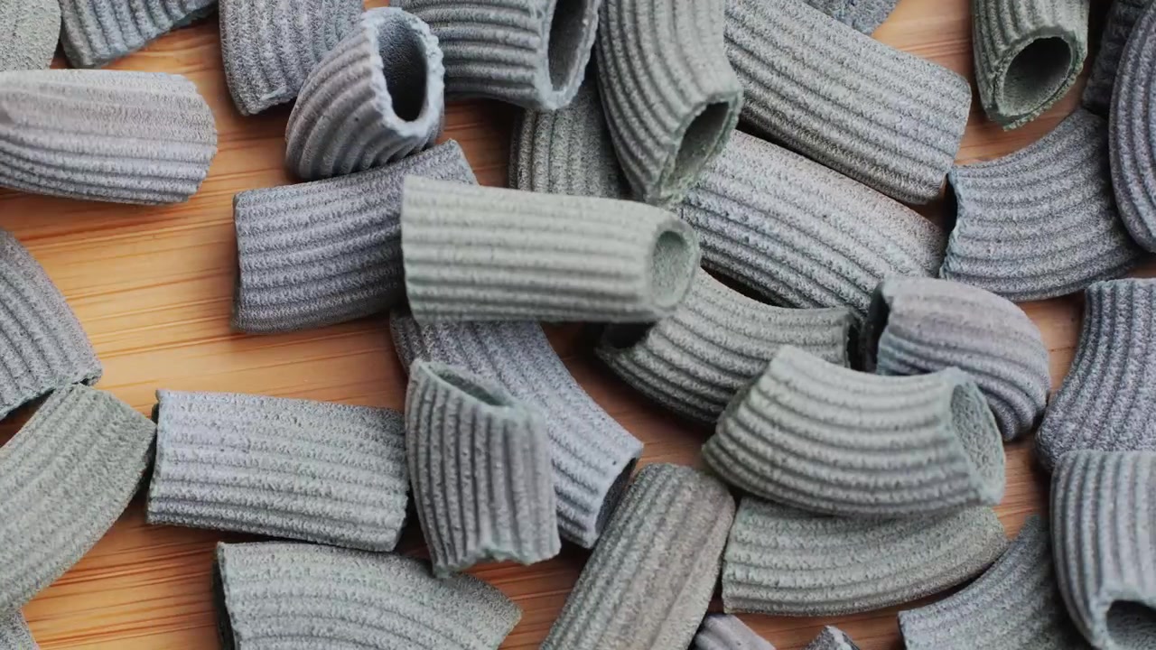 Pasta integrale biologica, maccheroni di semola di grano duro, penne rigate crude in una ciotola di legno. Filmato 4k di alta qualità