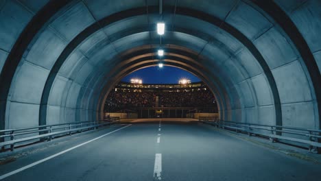 tunnel leading to a stadium filled with spectators at night
