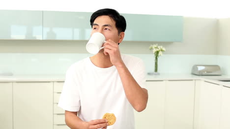 attractive man eating cookie and drinking