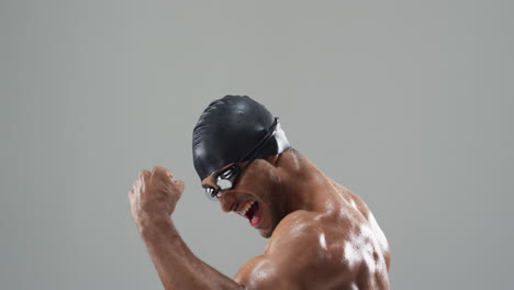 athlete celebrating victory in a swimming cap and goggles