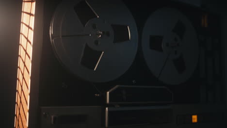 a vintage tape recorder spinning spools in a red blinking light