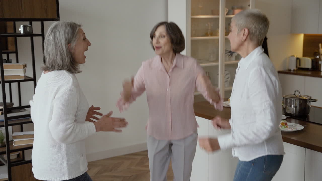 Three Joyful Senior Women Cheering And Hugging At Home