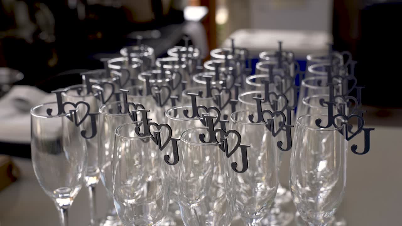 A collection of elegant glasses is neatly arranged, showcasing playful heart-shaped markers that symbolize love and joy at a special celebration. Perfect for memorable events