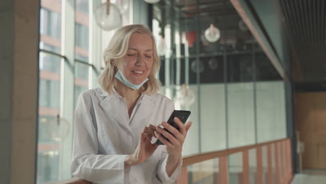 a blonde, middle aged female doctor sends a mobile phone text message 1