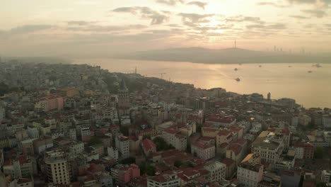 beautiful early morning above istanbul taksim with galata tower in sunrise light, aerial establishing shot slide left