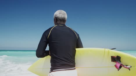 senior man running with a surfboard