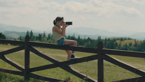 young girl photographer shooting landscape young photographer shooting landscape on beautifull green hillway taking pictures of nature girl filling the portfolio with amazing photos spending leisure time outdoor slow motion