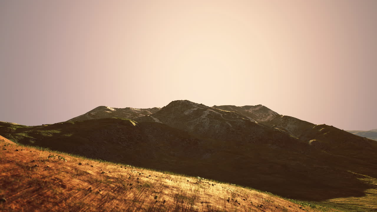 Majestic mountains bathed in golden sunlight during the tranquil sunset hour