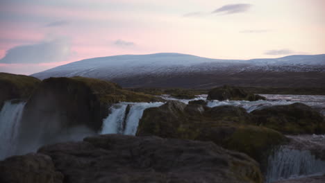 parte superior de la cascada al atardecer con montañas islandesas al fondo