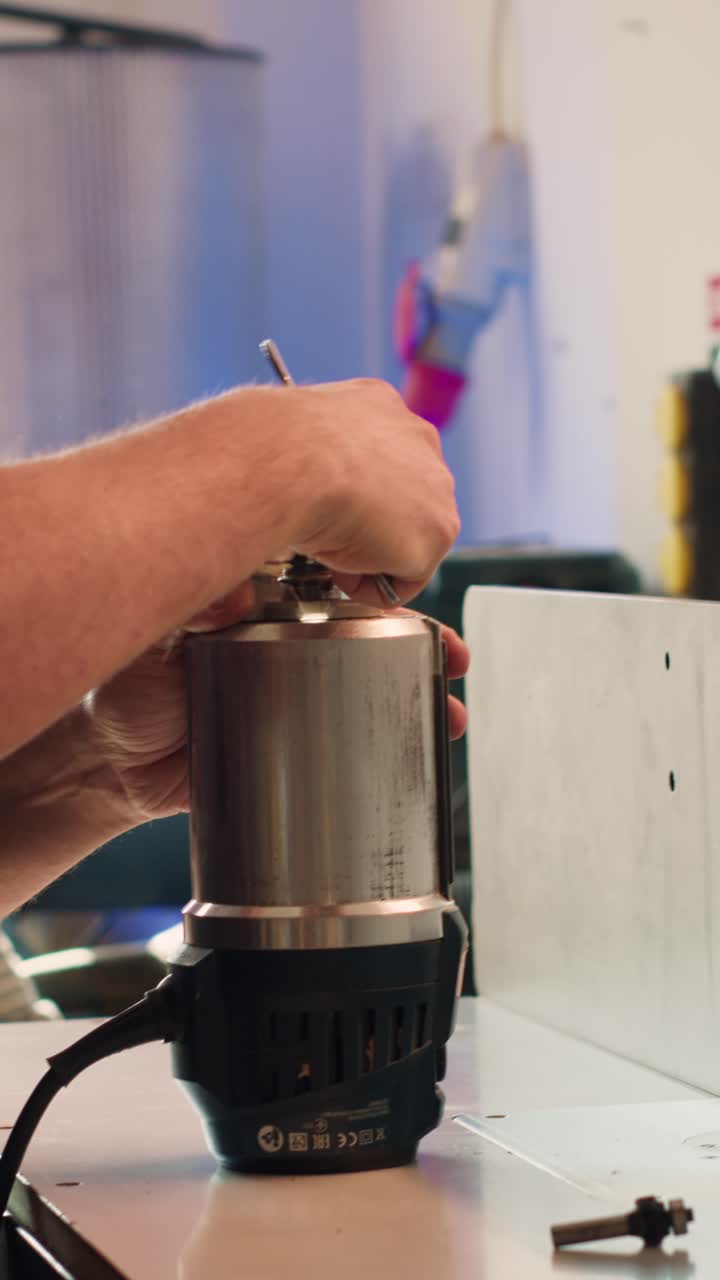 Worker's Hands Adjusting Router Bit on Power Tool