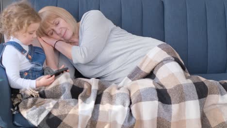 small child enjoys playing games on his smartphone at home preschool age child enjoys playing games on smartphone at home