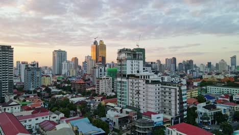 Slow-aerial-forward-shot-of-cambodian-residential-area-with-colorful-rooftops-during-sunset-in-Phnom-Penh