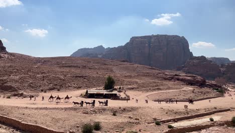 Petra-valley-in-Wadi-Musa,-Jordan-with-The-Treasury-in-the-middle-of-a-rocky-and-mountainous-landscape,-an-UNESCO-heritage-site,-ancient-Nabatean-Kingdom-4K-Establish-Shot