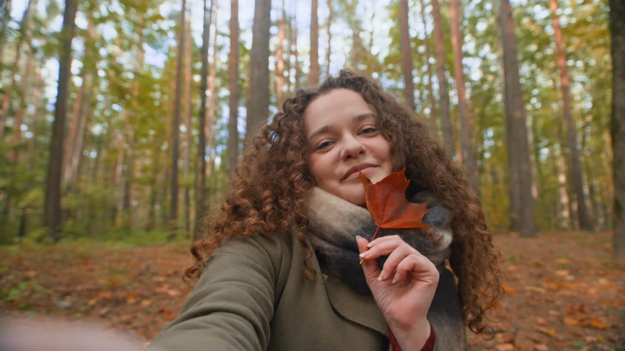 Woman Holding an Autumn Leaf in the Forest