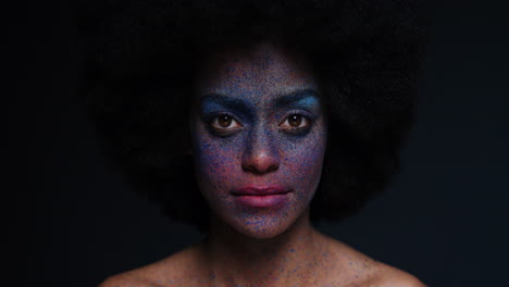 retrato de una hermosa mujer afroamericana con rostro exótico, pintura corporal, arte corporal, mujer misteriosa con maquillaje colorido, luz parpadeando en un fondo oscuro, concepto de expresión creativa