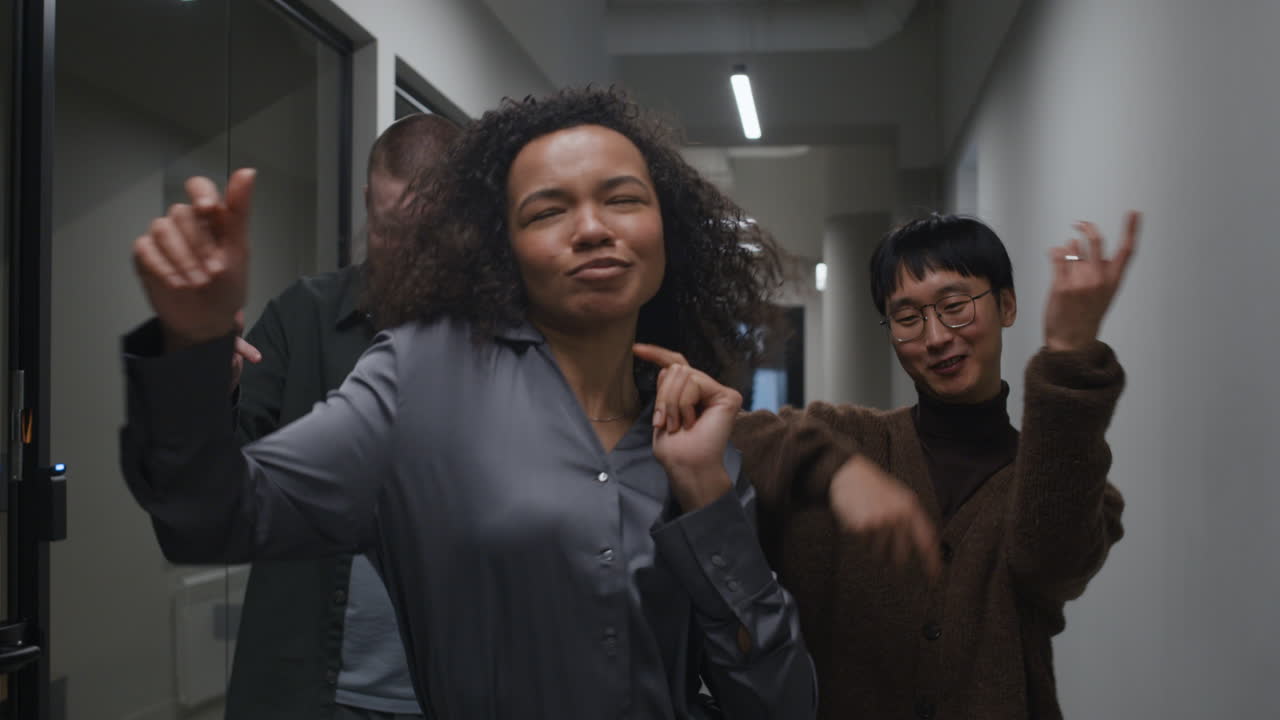 Group of Colleagues Dancing in Office Hallway