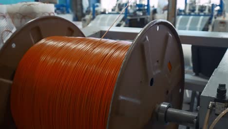 orange wire coil on reel in industrial setting