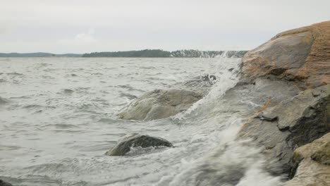 ocean waves crashing on rocks on a cloudy day