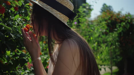mujer oliendo flores en un jardín